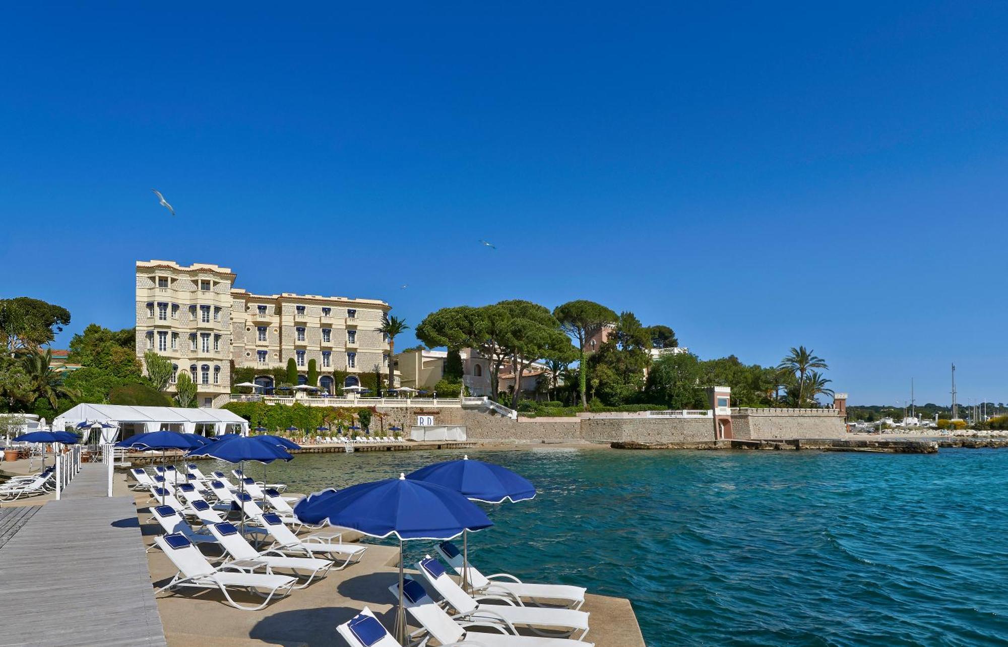 una donna in un salone di bellezza con uno specchio di Hôtel Belles Rives a Juan-les-Pins
