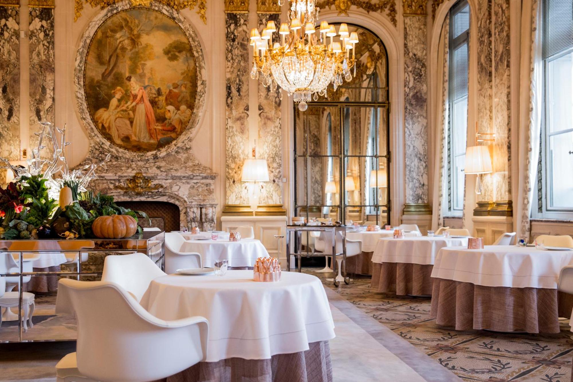un gruppo di sedie a sdraio e ombrelloni vicino all'acqua di Hôtel Belles Rives a Juan-les-Pins