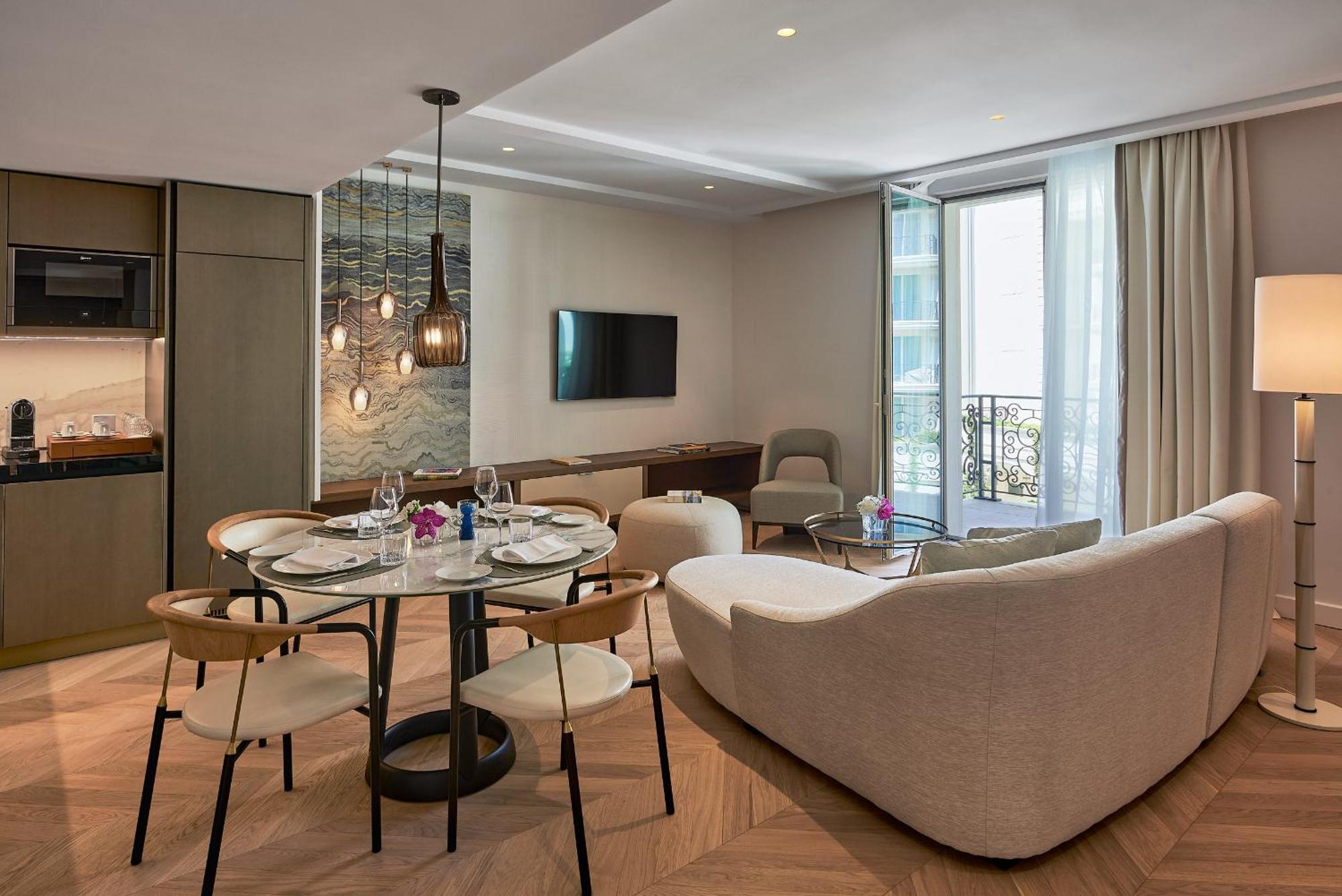 un soggiorno e una cucina con tavolo e sedie di Carlton Cannes, a Regent Hotel a Cannes